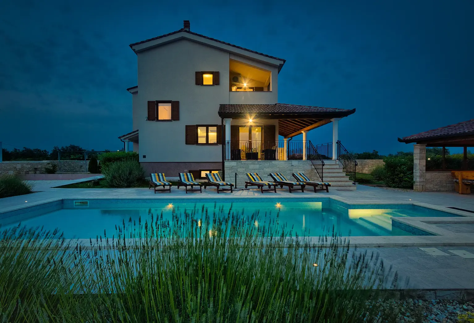 Außenansicht mit beleuchtetem Pool bei Einbruch der Dunkelheit – Villa Štokovci, Ferienhaus in Istrien
