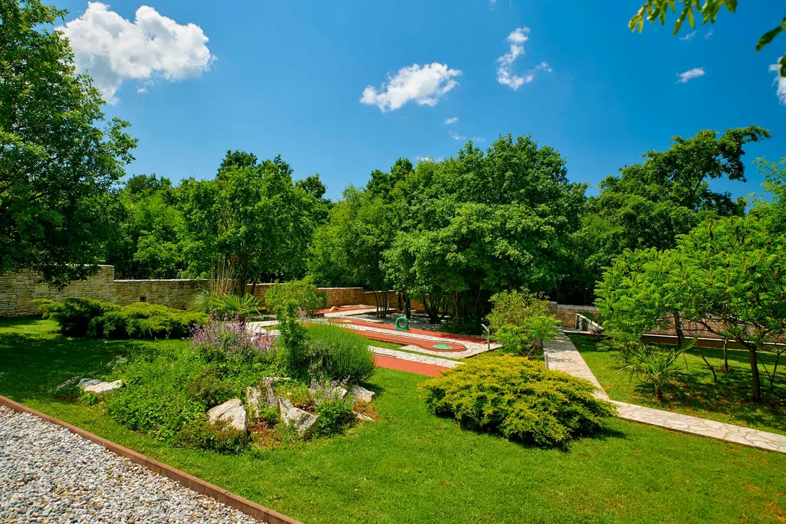 Blick auf die Minigolfanlage zwischen Bäumen und Grünflächen – Villa Štokovci, Ferienhaus in Istrien