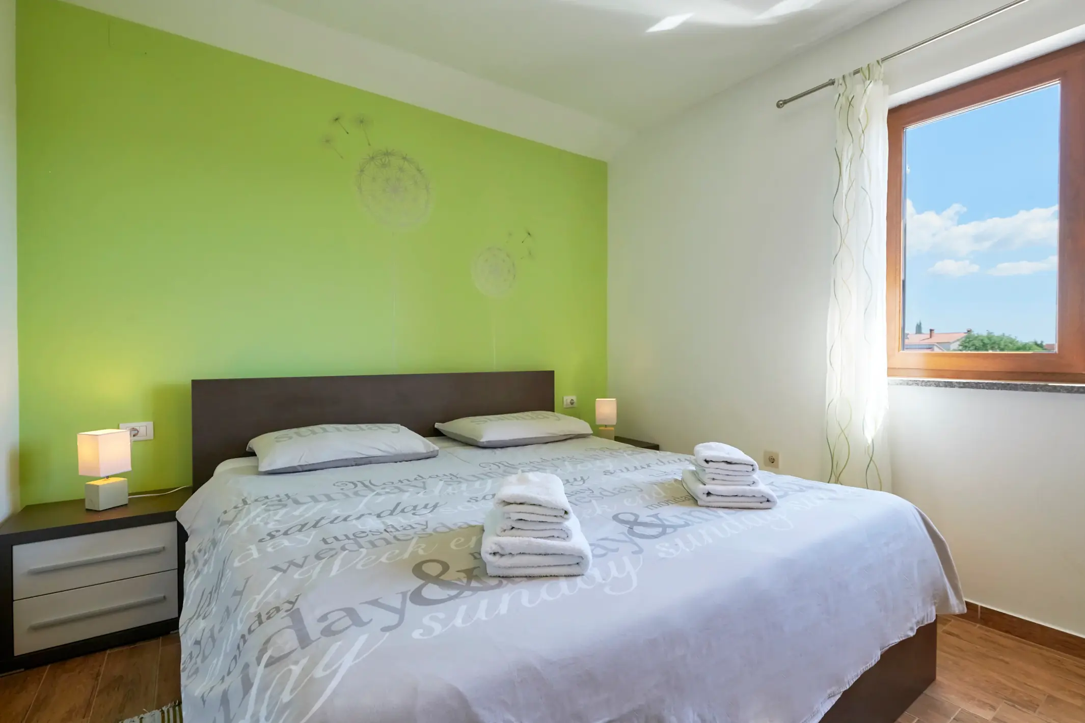 Doppelbett vor einer grünen Akzentwand – Villa Štokovci, Ferienhaus in Istrien
