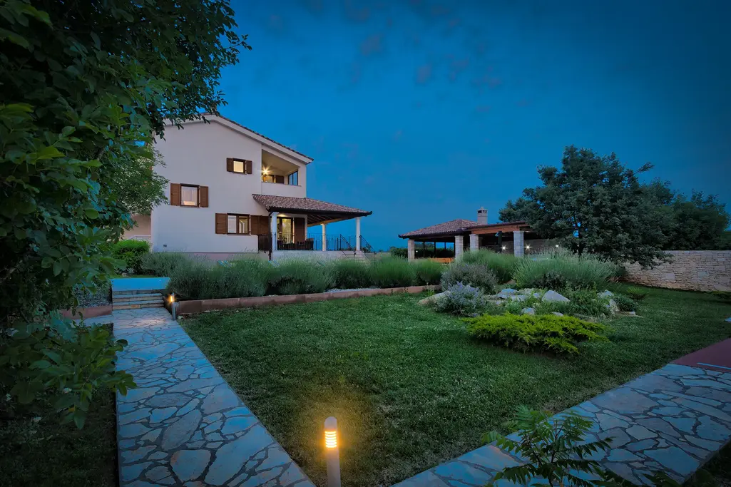 Blick über den Pool zur beleuchteten Ferienvilla – Villa Štokovci, Ferienhaus in Istrien
