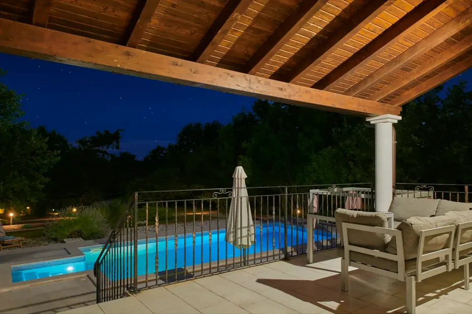 Sitzplatz unter dem Terrassendach mit beleuchtetem Pool – Villa Štokovci, Ferienhaus in Istrien