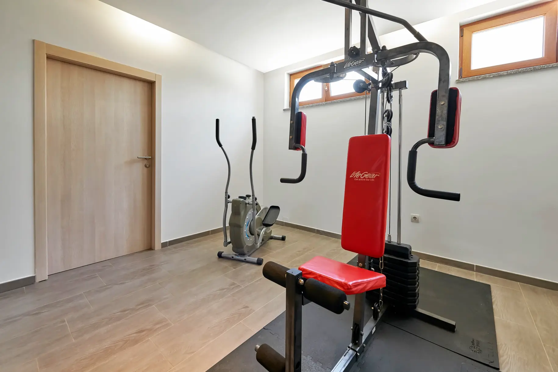 Fitnessraum der Villa Štokovci mit Kraftstation und Crosstrainer im Untergeschoss